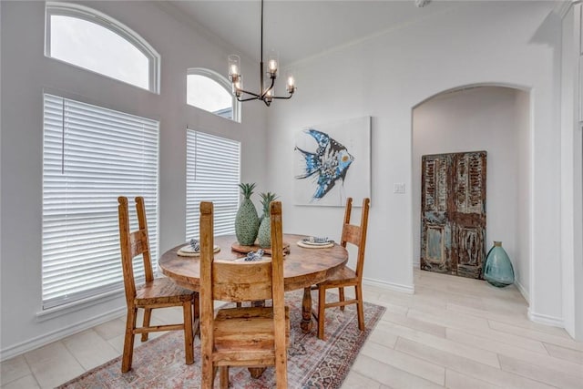 104 Emerald St, Portland, TX 78374 - dining room featuring arched walkways, ornamental molding, a chandelier, baseboards, and light wood-style flooring