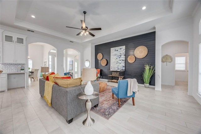 104 Emerald St, Portland, TX 78374 - living room with a raised ceiling, arched walkways, an accent wall, a ceiling fan, and recessed lighting