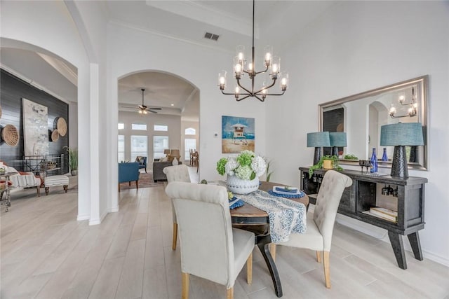 104 Emerald St, Portland, TX 78374 - dining space with arched walkways, a chandelier, a tray ceiling, light wood finished floors, and crown molding