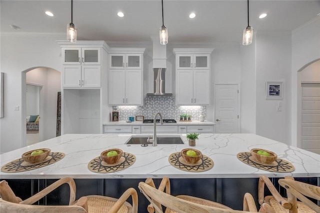 104 Emerald St, Portland, TX 78374 - kitchen with arched walkways, a sink, wall chimney exhaust hood, tasteful backsplash, and pendant lighting