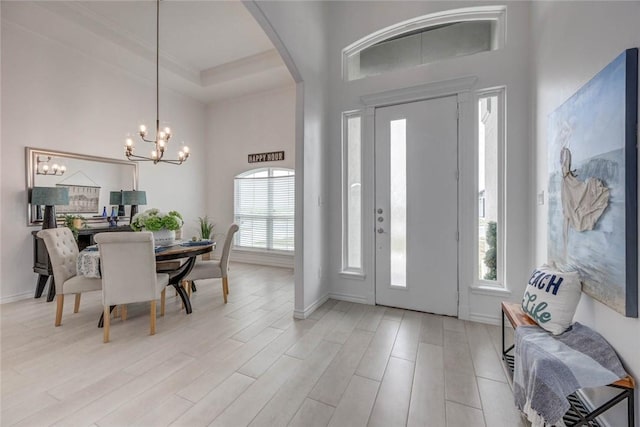 104 Emerald St, Portland, TX 78374 - foyer entrance with a chandelier, arched walkways, a towering ceiling, light wood-style flooring, and baseboards