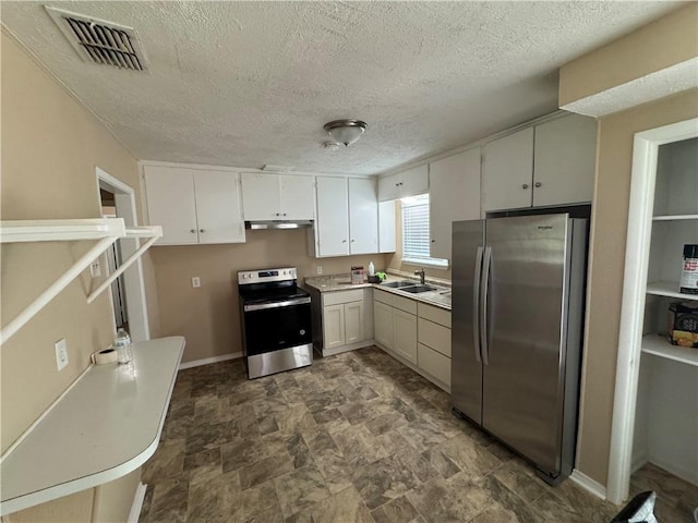 913 Clare Dr, Corpus Christi, TX 78412 - kitchen featuring appliances with stainless steel finishes, under cabinet range hood, stone finish floors, a textured ceiling, and light countertops