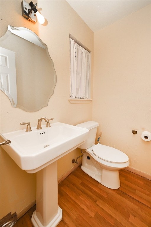 bathroom featuring hardwood / wood-style flooring and toilet