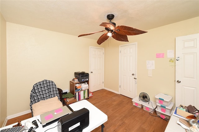 miscellaneous room with hardwood / wood-style flooring, ceiling fan, and a textured ceiling