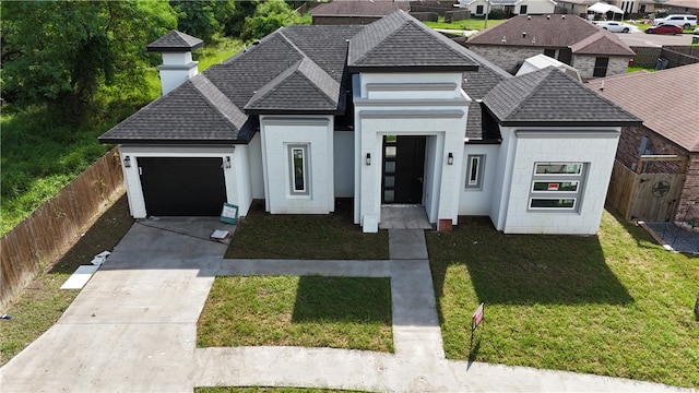 view of front of home featuring a front lawn and a garage