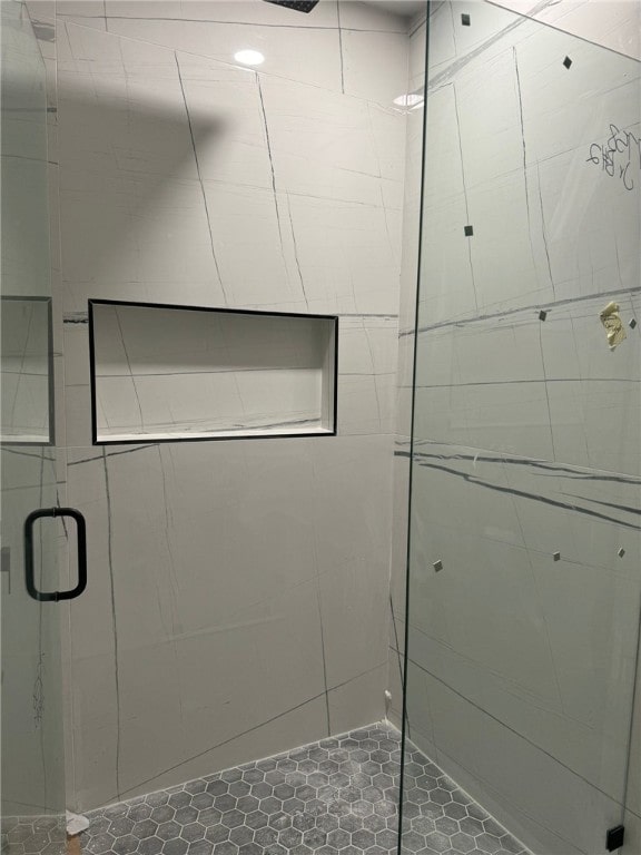 bathroom featuring a shower with door