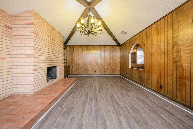 unfurnished living room featuring wooden walls and dark hardwood / wood-style floors