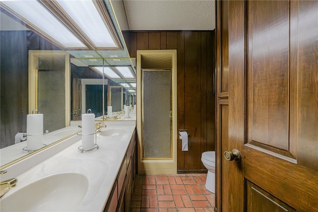 bathroom featuring wood walls, a shower with shower door, vanity, and toilet