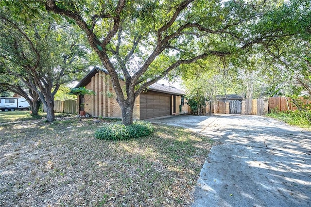 743 Retama Ave, Taft, TX 78390 - view of side of home with driveway, fence, and an attached garage