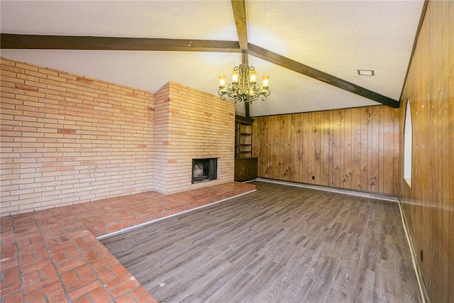 unfurnished living room featuring wood walls, wood-type flooring, and a fireplace