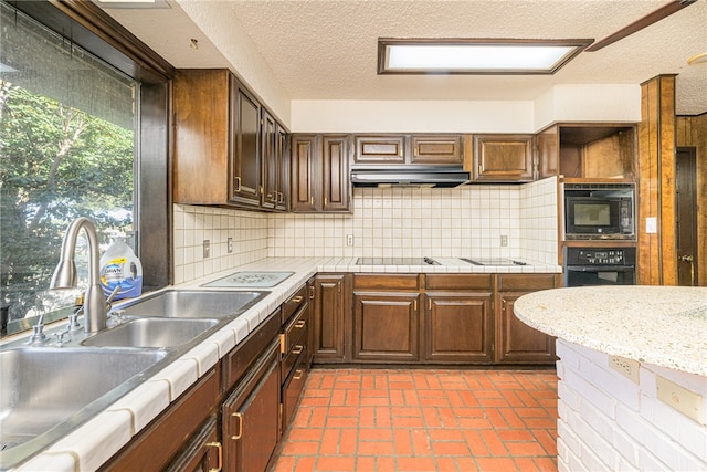 kitchen with decorative backsplash, black appliances, and a textured ceiling