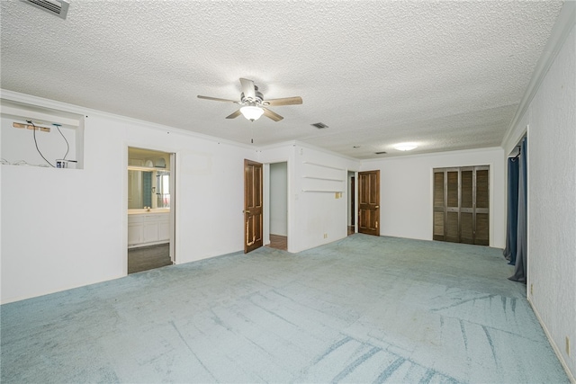 unfurnished room featuring ornamental molding, ceiling fan, a textured ceiling, and carpet