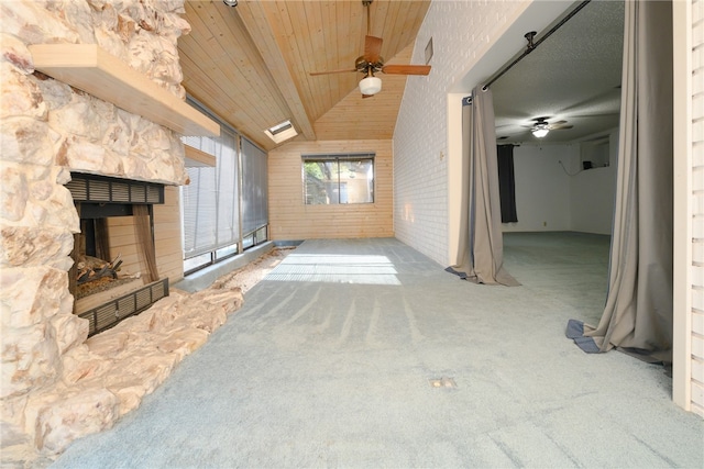 unfurnished living room featuring carpet, a fireplace, lofted ceiling, and ceiling fan