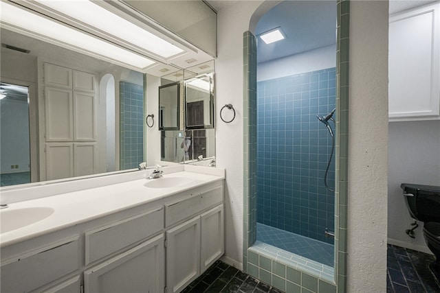 bathroom featuring vanity, tile patterned floors, and a tile shower