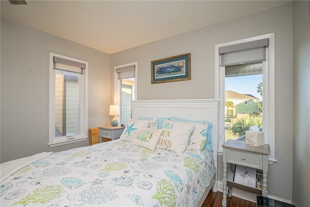 bedroom with dark hardwood / wood-style flooring