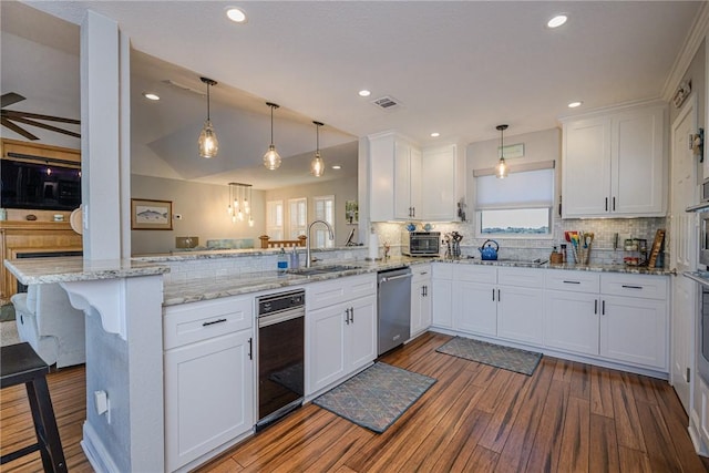 kitchen featuring hanging light fixtures, white cabinets, and kitchen peninsula