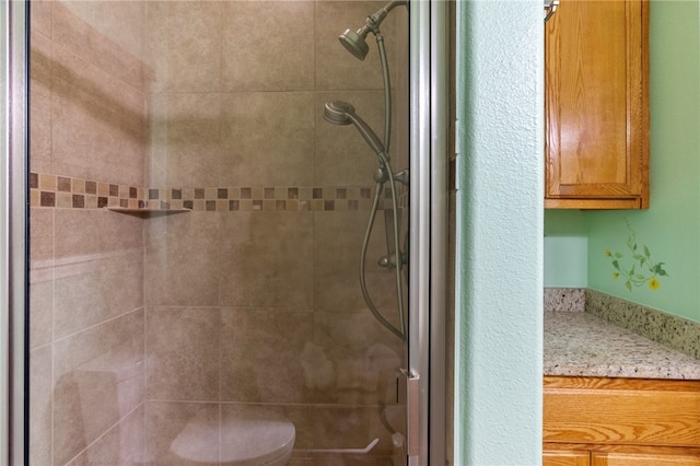 bathroom featuring toilet and a shower with shower door