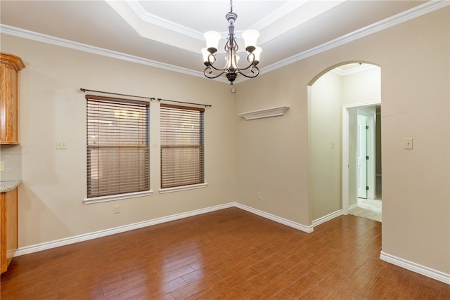 unfurnished dining area with wood-type flooring, a chandelier, and crown molding