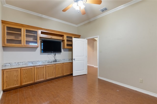 kitchen featuring ceiling fan, light stone counters, dark hardwood / wood-style flooring, and ornamental molding