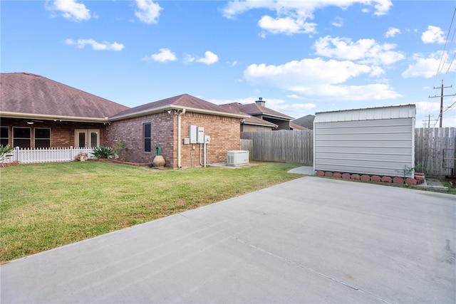 view of property exterior featuring central AC unit, a yard, and a storage shed