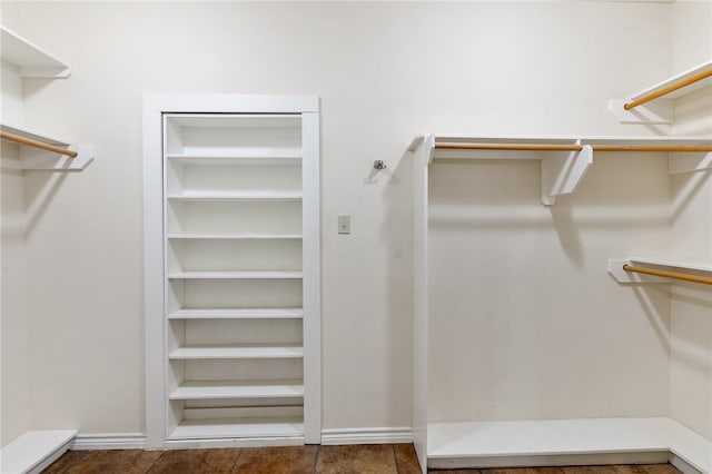 spacious closet with dark tile patterned floors