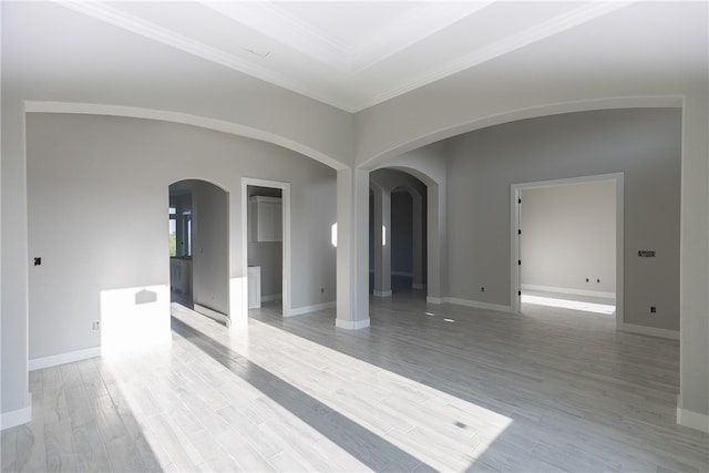 empty room with light hardwood / wood-style flooring and crown molding