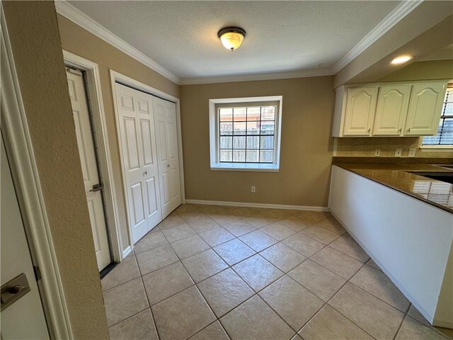 6313 Ramsgate Cir, Corpus Christi, TX 78414 - unfurnished dining area featuring plenty of natural light, ornamental molding, a textured ceiling, baseboards, and light tile patterned floors