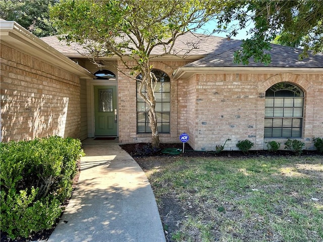 6313 Ramsgate Cir, Corpus Christi, TX 78414 - doorway to property with brick siding, roof with shingles, and a lawn