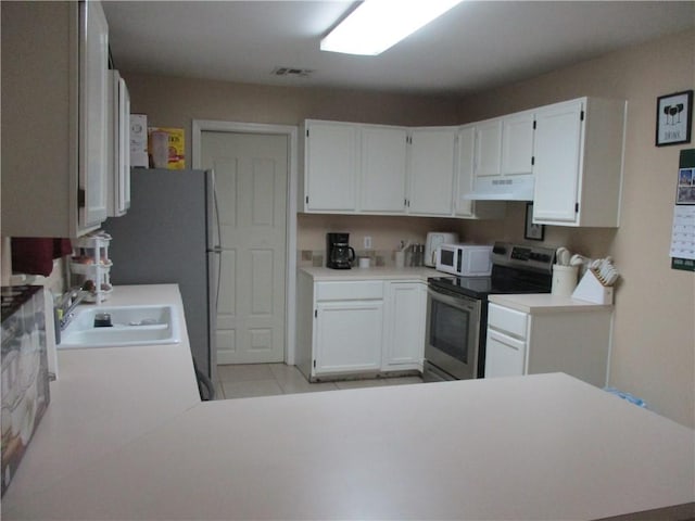 kitchen with sink, white cabinets, light tile patterned floors, stainless steel electric range oven, and kitchen peninsula