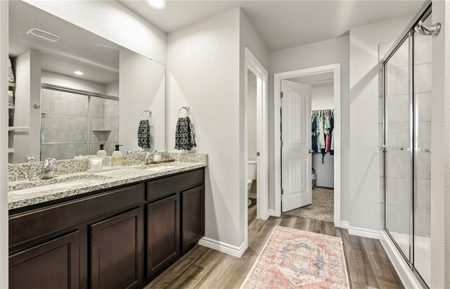 1293 Carnaby St, Corpus Christi, TX 78415 - bathroom with a shower stall, wood finished floors, double vanity, and a spacious closet