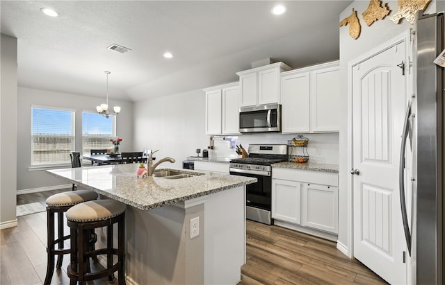 1293 Carnaby St, Corpus Christi, TX 78415 - kitchen featuring stainless steel appliances, backsplash, dark wood-style flooring, recessed lighting, and a kitchen island with sink