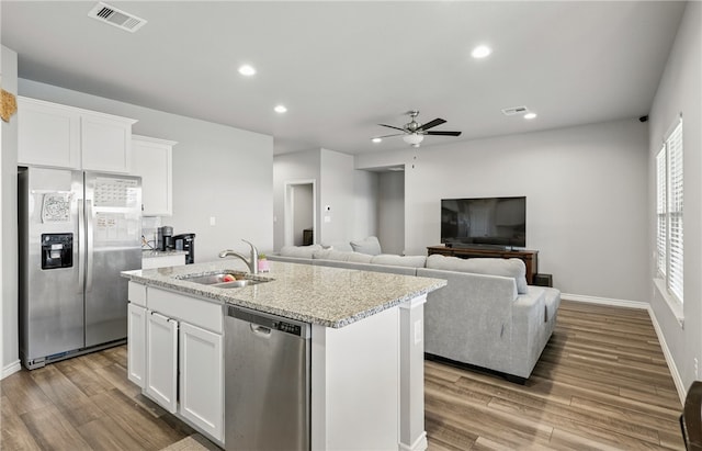 1293 Carnaby St, Corpus Christi, TX 78415 - kitchen with stainless steel appliances, wood finished floors, ceiling fan, white cabinets, and a center island with sink