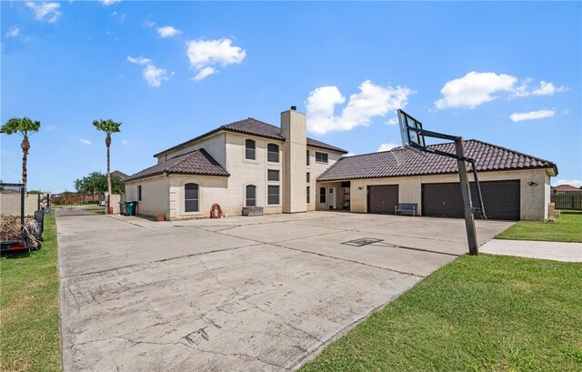 5413 King Trl, Corpus Christi, TX 78414 - rear view of property featuring a tile roof, driveway, a chimney, a garage, and stucco siding