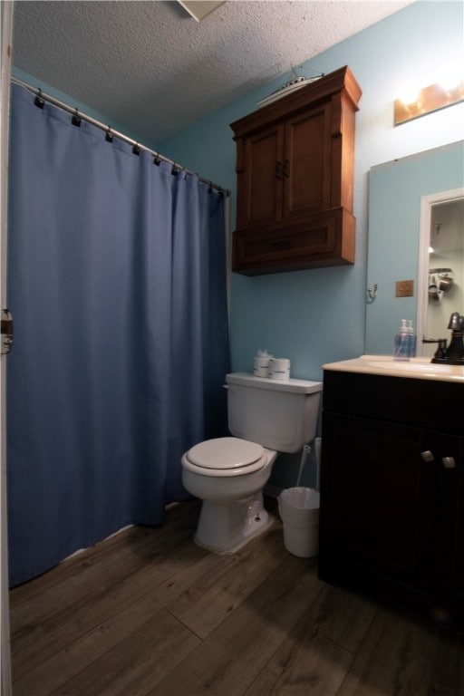 bathroom with vanity, hardwood / wood-style flooring, a textured ceiling, and toilet