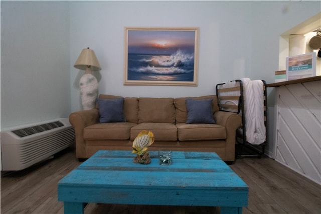 living room featuring hardwood / wood-style floors and an AC wall unit