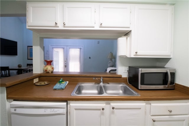 kitchen with white cabinets, sink, and white dishwasher