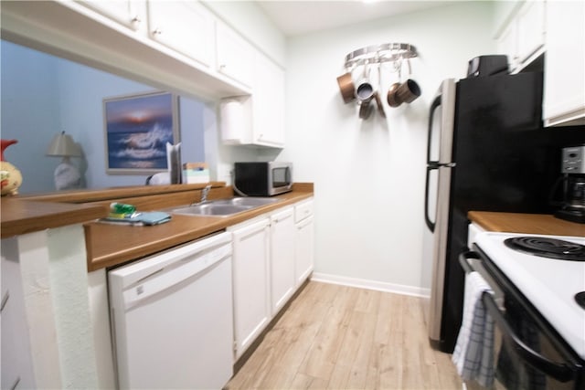 kitchen featuring white appliances, sink, light hardwood / wood-style floors, and white cabinets