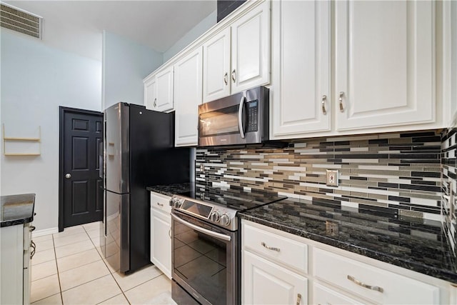 4230 Rapids Dr, Corpus Christi, TX 78410 - kitchen featuring appliances with stainless steel finishes, backsplash, white cabinets, light tile patterned flooring, and dark stone counters
