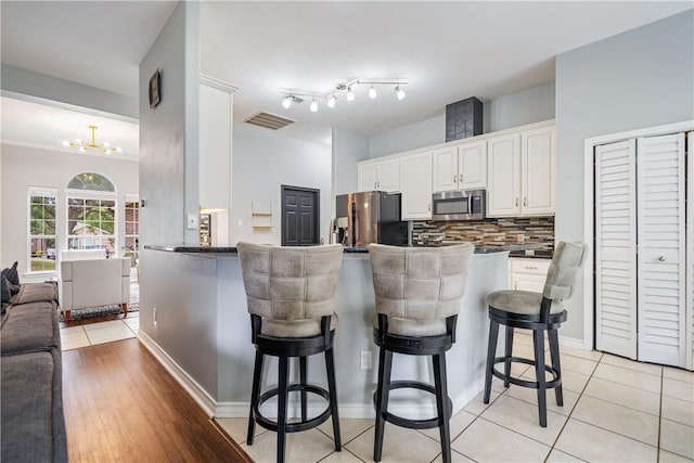 4230 Rapids Dr, Corpus Christi, TX 78410 - kitchen with stainless steel appliances, dark countertops, a breakfast bar, open floor plan, and decorative backsplash