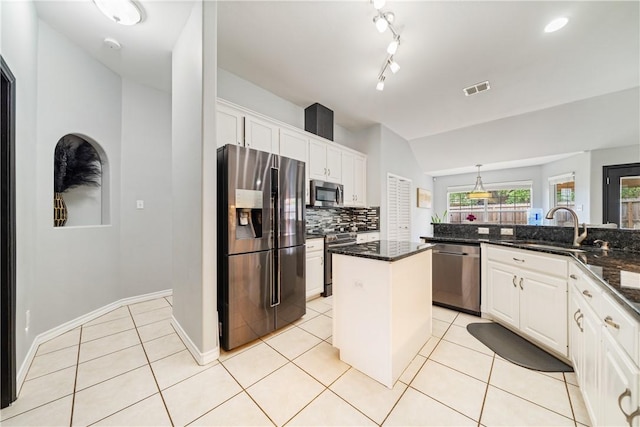 4230 Rapids Dr, Corpus Christi, TX 78410 - kitchen with appliances with stainless steel finishes, a sink, white cabinetry, vaulted ceiling, and tasteful backsplash