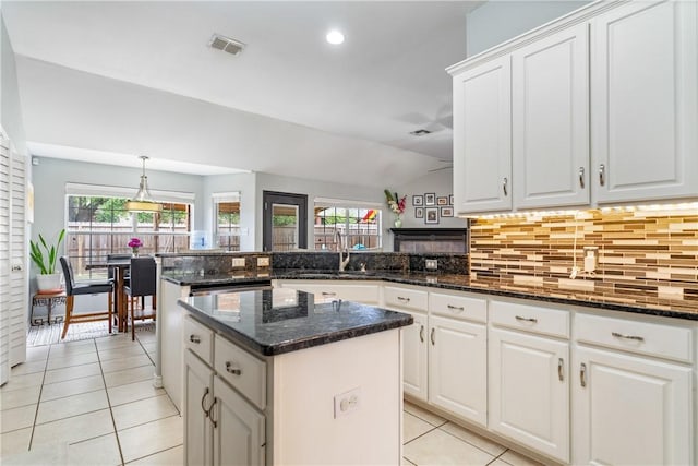 4230 Rapids Dr, Corpus Christi, TX 78410 - kitchen with light tile patterned floors, a sink, a peninsula, backsplash, and lofted ceiling