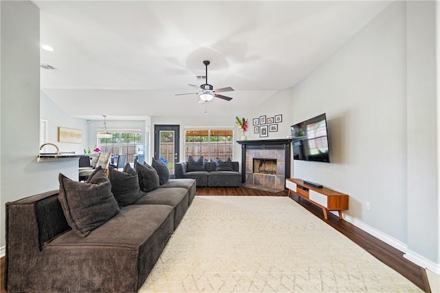 4230 Rapids Dr, Corpus Christi, TX 78410 - living room featuring dark wood-style floors, lofted ceiling, baseboards, ceiling fan, and a tile fireplace