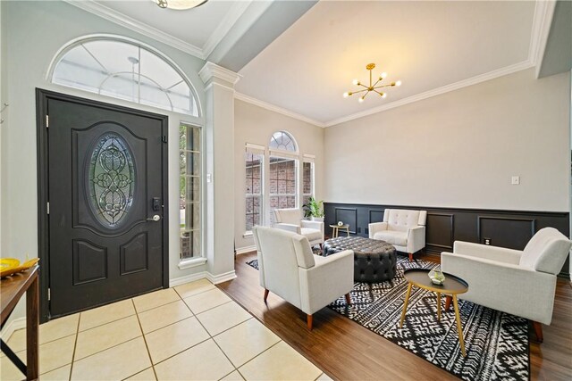 4230 Rapids Dr, Corpus Christi, TX 78410 - foyer entrance featuring crown molding, a chandelier, wood finished floors, wainscoting, and decorative columns