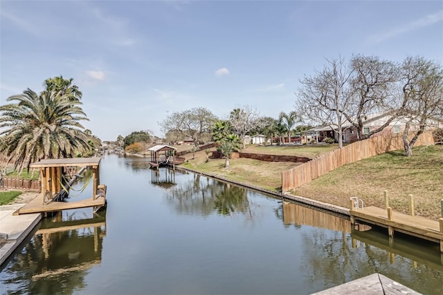 dock area with a lawn, a water view, and fence