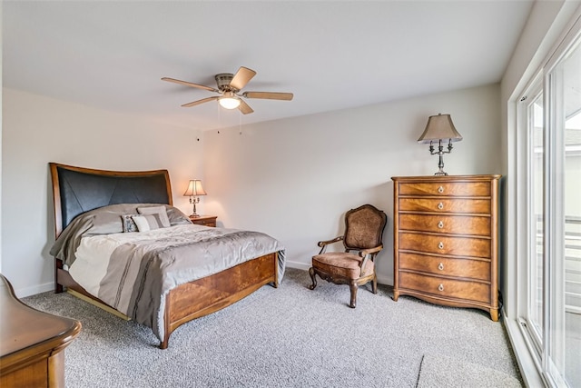 carpeted bedroom with ceiling fan and baseboards