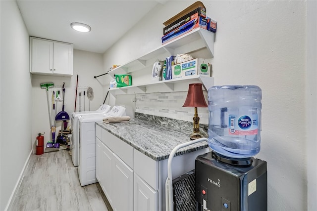 laundry room featuring light wood-style floors, cabinet space, baseboards, and separate washer and dryer