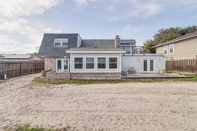 back of property with a patio area, a fenced backyard, french doors, and brick siding