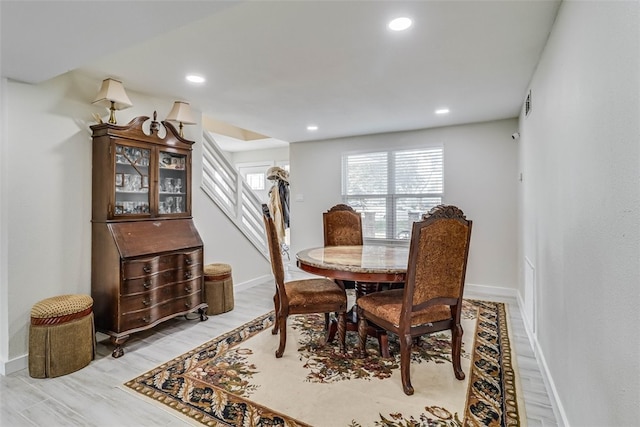 dining room with light wood-style floors, baseboards, stairway, and recessed lighting