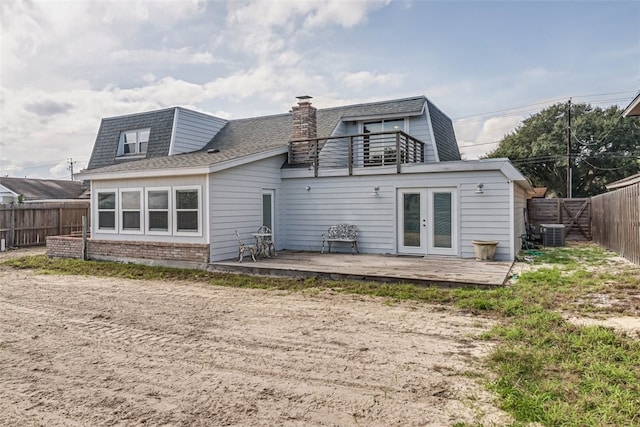 rear view of property featuring french doors, a fenced backyard, brick siding, and central air condition unit