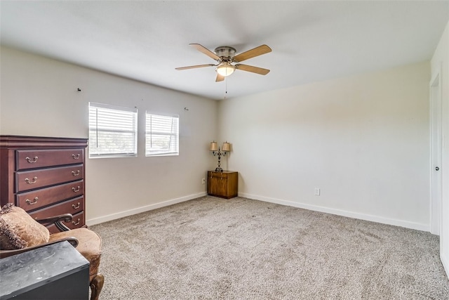 sitting room with ceiling fan, baseboards, and light colored carpet